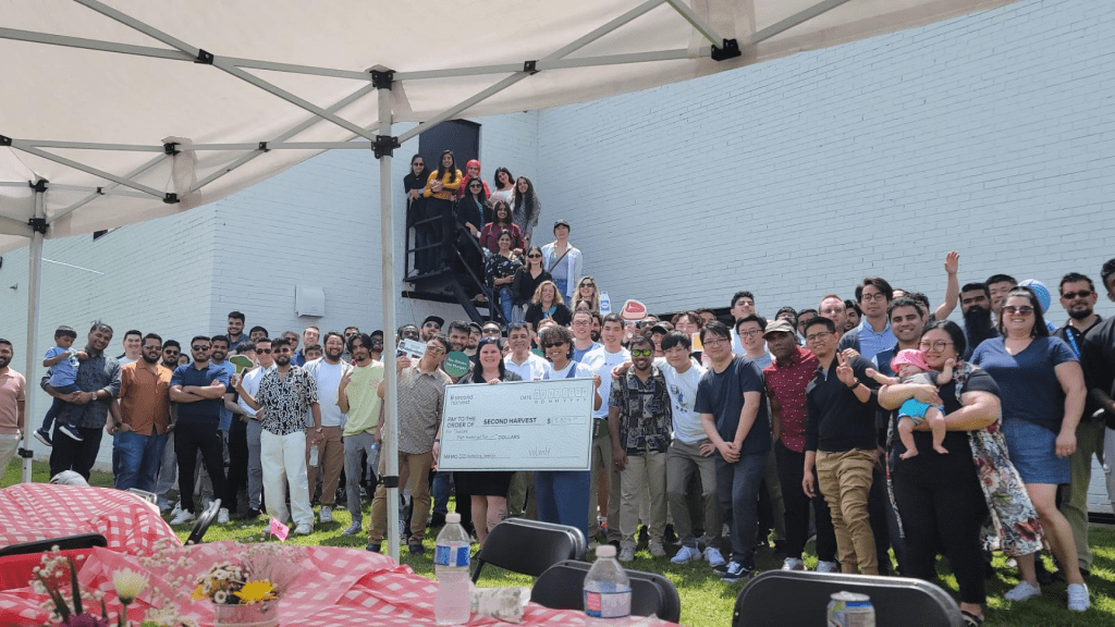 Volante Systems employees gathered at team BBQ fundraiser for Second Harvest. They hold check signed to Second Harvest.